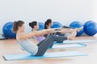 © WavebreakMediaMicro - Side view of class stretching on mats at yoga class