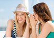 © Syda Productions - girls gossiping in cafe on the beach
