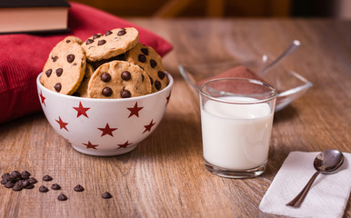 Wall Mural - Chocolate chip cookies and milk on wood background