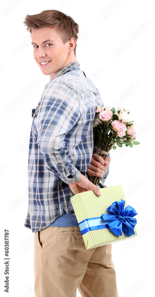 Handsome young man with flowers and gift, isolated on white
