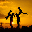 © altanaka - Happy  family playing on the  road in the  sunset time. Evening