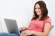 © Andrey Popov - Woman Sitting On Couch Using Laptop