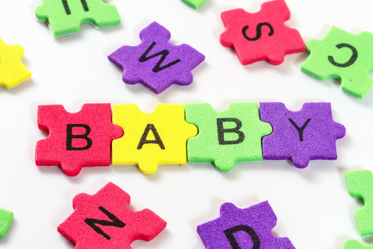 word BABY formed with colorful foam puzzle  on white background