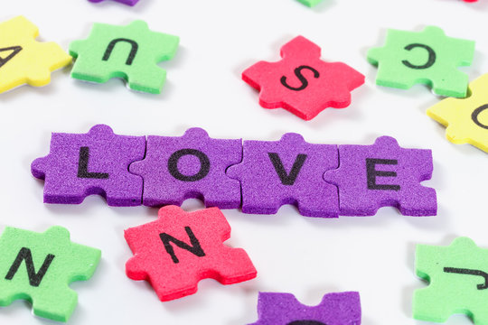 word LOVE formed with colorful foam puzzle  on white background