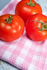 three tomatoes on a plaid towel