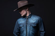 © ysbrandcosijn - Modern fashion cowboy. Wearing brown hat and blue jeans shirt. B