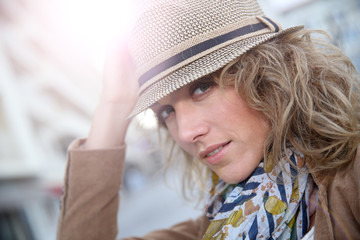 Wall Mural - Cheerful blond woman in town with hat on