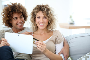 Sticker - Cheerful couple at home e-shopping with tablet