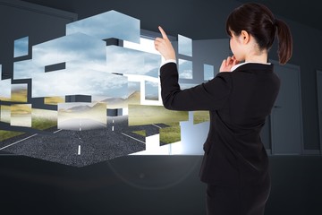 Poster - Composite image of thoughtful businesswoman pointing