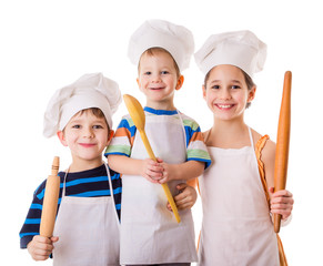 Three young chefs with ladle and rolling pin