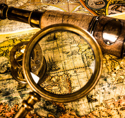 Vintage magnifying glass lies on an ancient world map