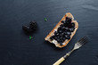 Healthy breakfast with blackberry jam with toast on black slate