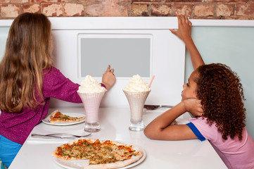 Wall Mural - Little girls enjoying pizza in a restaurant