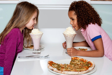 Wall Mural - Young girls sipping strawberry shake