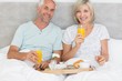 © WavebreakmediaMicro - Happy mature couple having breakfast in bed