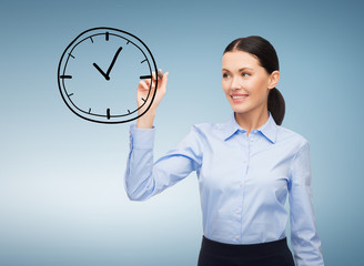 businesswoman drawing clock in the air