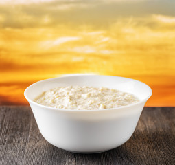 Wall Mural - Bowl of oat porridge on nature background