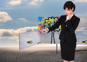Poster - Composite image of thoughtful businesswoman pointing