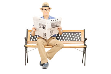 Poster - Young man seated on a wooden bench holding newspaper