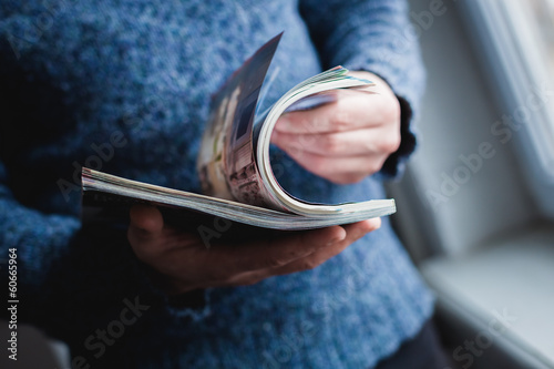 Photographie Un homme regarde un magazine. Appuyez sur les mains.