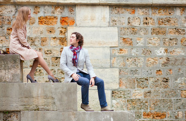 Dating couple sitting on the Seine embankment