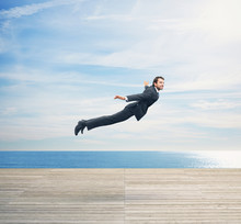 Man In Suit Flying Over Boardwalk