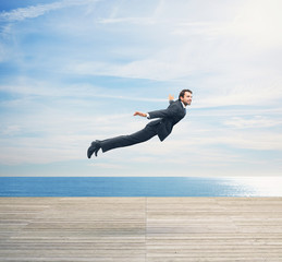 man in suit flying over boardwalk