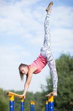 Agile Young Gymnast Balancing On Cross Bars