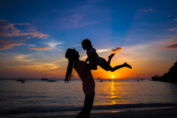 Poster - Little girl and her mother having fun at sunset on the island