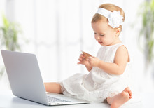 Baby Girl With Laptop And Credit Card Shopping On Internet