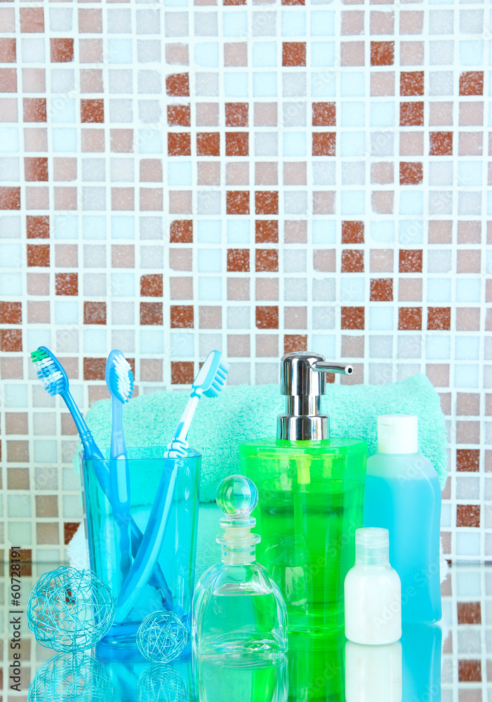 Cosmetics and bath accessories on mosaic tiles background