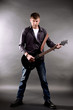 © Africa Studio - Young musician playing  guitar on gray background