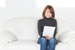 © miya227 - ソファでタブレットを見る女性