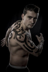 Man inked with black tribal design, tattoo