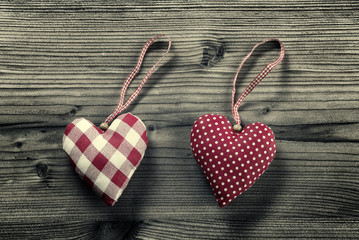 2 pieces of fabric hearts on wood background