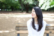 © blanche - 公園のベンチに座る女性