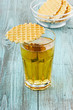 Apple juice in a glass with wafer cookies on a wooden surface