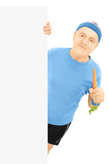 Sticker - Mature sportsman holding a carrot and posing behind panel