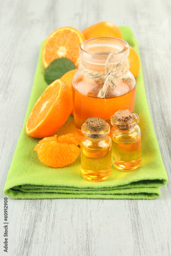 Tangerine essential oil and tangerines on wooden table