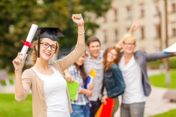 Wall Mural - smiling teenage girl in corner-cap with diploma