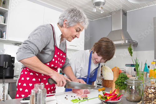 Foto Familie: Enkel mit der Großmutter in der Küche beim Kochen
