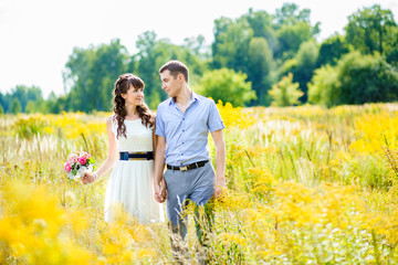 portrait of a boy and a girl walking in a field of tall yellow g