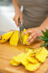 Wall Mural - Closeup on young woman cutting pineapple