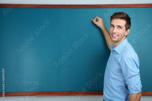 Fotografía Young teacher near chalkboard in school classroom