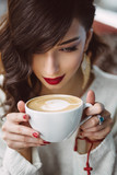 Fototapeta Tematy - Young girl drinking coffee in a trendy cafe