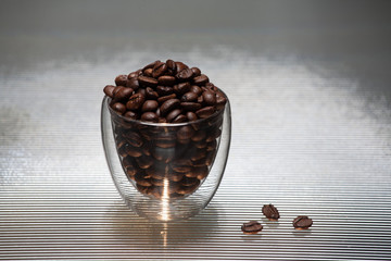 Glass with coffee grains on a color background.