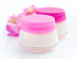 © nmelnychuk - Cosmetic creams  and pink flowers isolated on white background