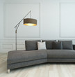 Gray couch and floor lamp against white wall