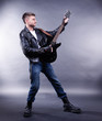 © Africa Studio - Young musician playing  guitar on gray background