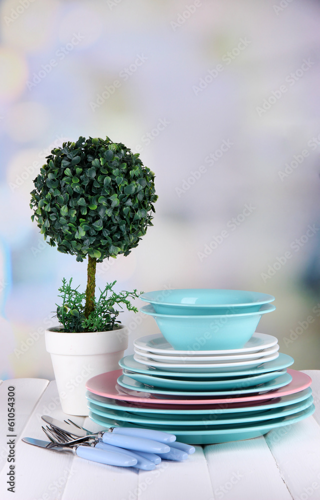 Clean dishes with flower on wooden table on natural background